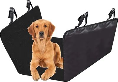 A golden retriever dog is lying in a black car seat cover designed to protect the back seat from pets.