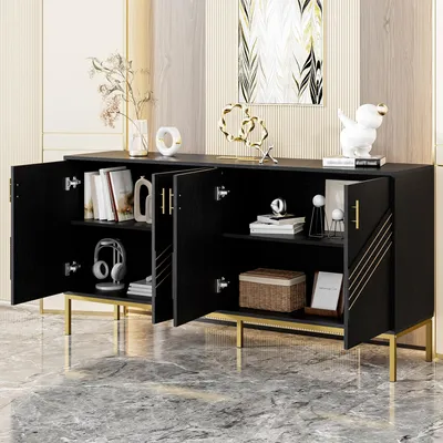 A black sideboard with gold legs and accents, featuring open doors revealing shelves with books, decorative items, and a basket. The sideboard is placed on a marble floor in a room with a striped wall and artwork.