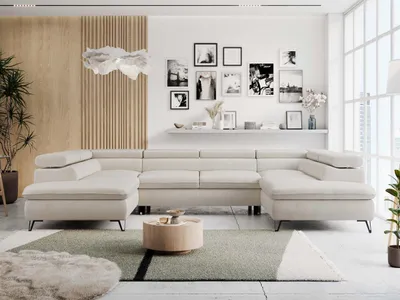 A modern living room with a large U-shaped sofa, coffee table, and decorative wall art.