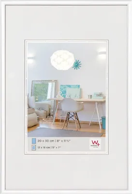 A white picture frame with a mat and a picture of a modern home office setup inside.