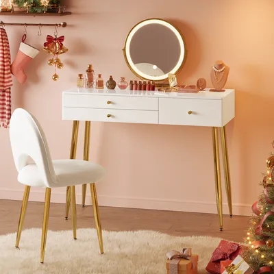 A vanity table with a lighted mirror, chair, and makeup products, decorated for the holidays with stockings and a Christmas tree.