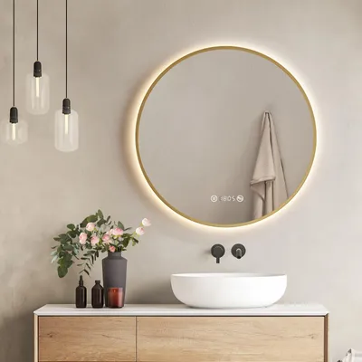 A modern bathroom vanity with a round LED mirror, a vessel sink, and decorative items.