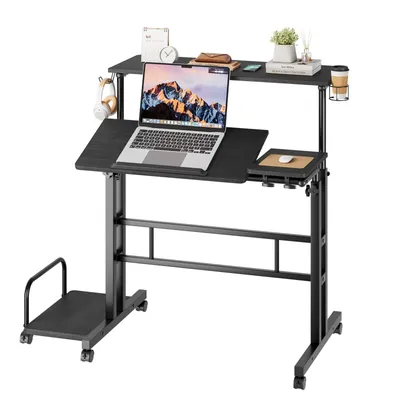 A black adjustable standing desk with a laptop and accessories on it, shown against a white background.