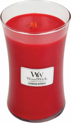 A red candle in a glass jar with a label.