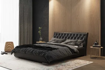 A modern bedroom setting with a large black tufted headboard bed.