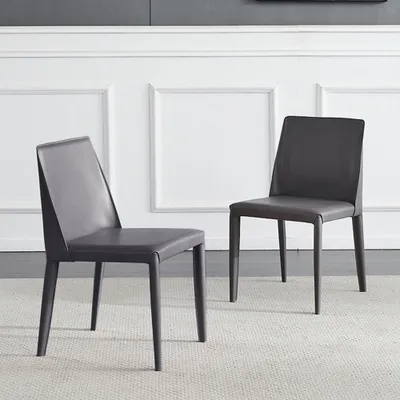 Two gray chairs are shown in a room with white paneled walls.