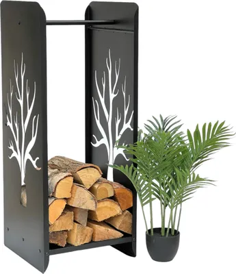 A black metal firewood rack with a tree silhouette design, filled with logs, stands next to a potted green plant.