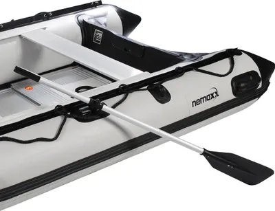 Close-up view of an inflatable boat with a paddle resting on it.