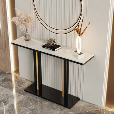 A console table with marble top and metal frame, decorated with vases and a book.