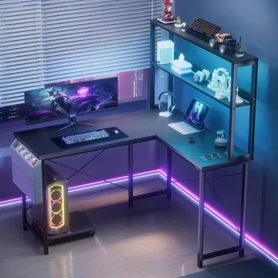 A modern gaming desk setup with a computer, monitor, keyboard, and shelves, illuminated by LED lights.