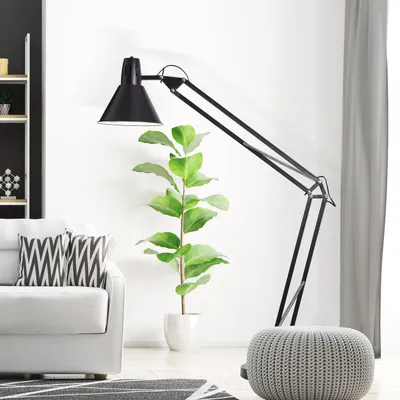 A modern living room scene with a floor lamp, sofa, and pouf.