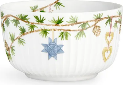 A white bowl decorated with a Christmas-themed pattern of pine branches and ornaments.
