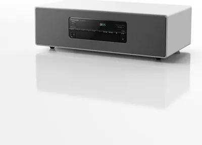 A white and gray Panasonic micro music system is shown on a reflective white surface.
