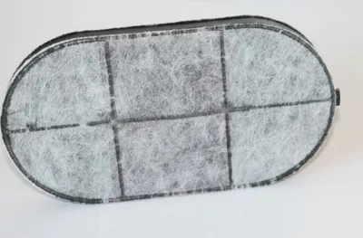 An oval-shaped charcoal filter for a deep fryer, seen from above.