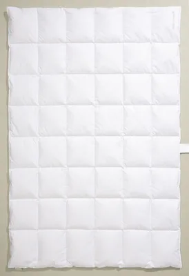 A white quilted duvet is laid flat against a light gray background.