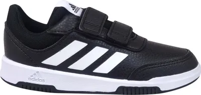 A black Adidas shoe with white stripes and white soles, featuring two velcro straps.
