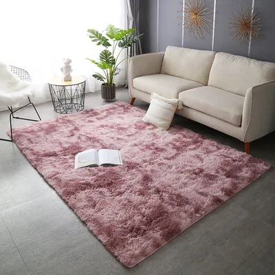 A living room scene with a pink shaggy rug, a beige sofa, a plant, and a side table.