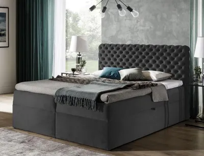 A bedroom scene with a large upholstered bed as the main focus.