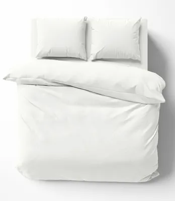A white duvet cover and two white pillowcases are neatly arranged on a white surface, suggesting a clean and minimalist aesthetic.
