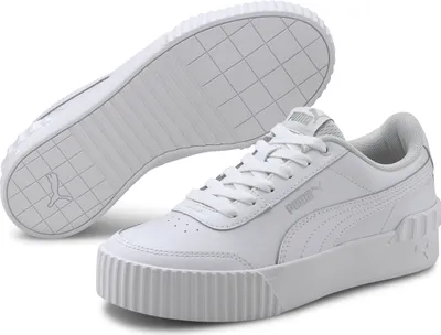 A pair of white Puma Carina Lift TW sneakers are shown from a slightly elevated angle, with one shoe in the foreground and the sole of the other shoe visible behind it.