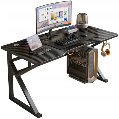 A gaming computer desk setup with a monitor, laptop, keyboard, mouse, and computer tower.