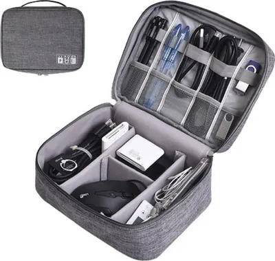 An open gray organizer bag filled with various electronic accessories like cables, USB sticks, a mouse, and power banks.