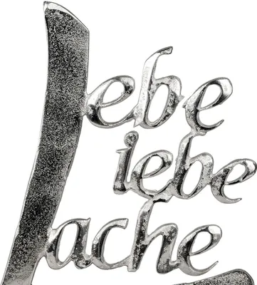 A close-up of a metallic decorative text sign.
