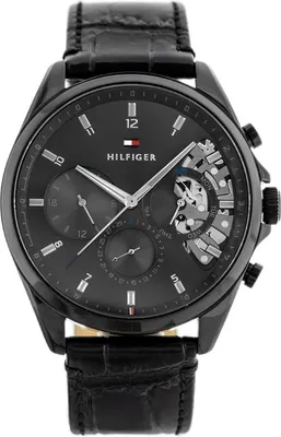 A close-up studio shot of a black Tommy Hilfiger men's watch with a black leather strap.