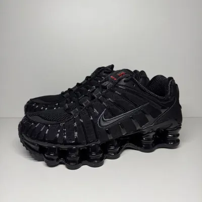 A pair of black Nike Shox TL sneakers are displayed against a plain light gray background.