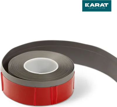 A roll of gray tape with a red adhesive backing is shown against a white background. A logo is visible in the top right corner.