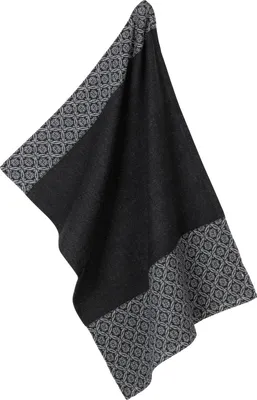 A black kitchen towel with a geometric pattern on the edges, hanging.