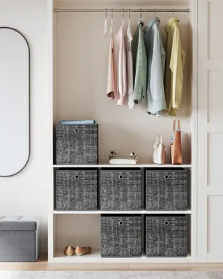 A closet interior with shelves displaying storage boxes, folded clothes, and hanging garments.