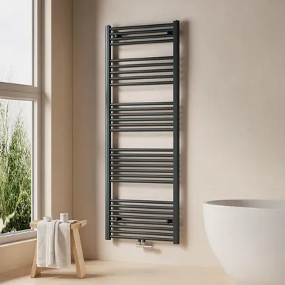 A modern bathroom with a dark grey towel radiator, a white bathtub, and a wooden stool with a folded towel.