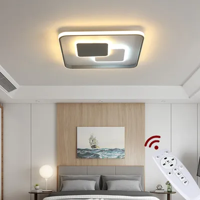 A modern bedroom with a ceiling light and a remote control.