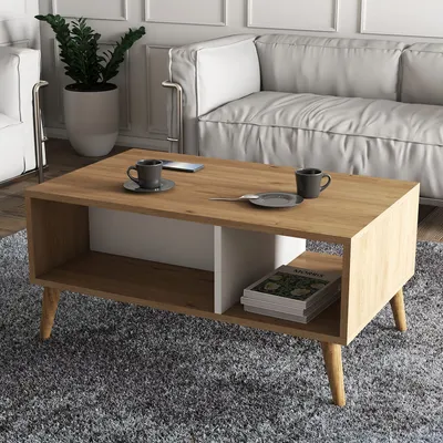 A modern living room with a coffee table in the foreground and a sofa in the background.