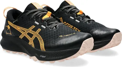 A pair of black and gold trail running shoes.