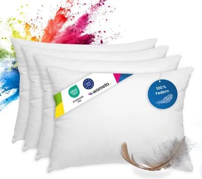 A stack of white pillows with colorful powder exploding behind them.