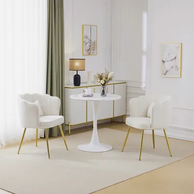 A set of two beige upholstered chairs and a small white tulip table in a well-lit room.