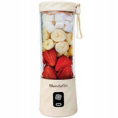 A portable blender filled with strawberries, bananas, and coconut pieces.