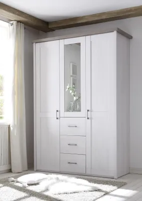 A white wardrobe with a mirrored door and three drawers is shown in a room with wooden beams on the ceiling and a white curtain on the left.