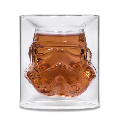 A glass with a stormtrooper helmet design filled with a brown liquid.