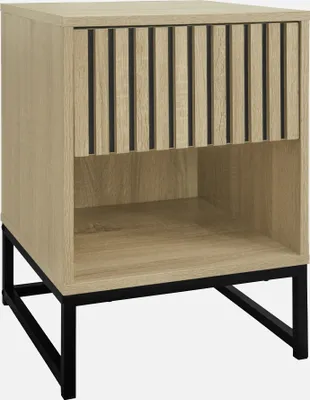 A modern nightstand with a slatted drawer front and open shelf, set on black metal legs.