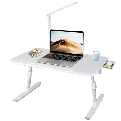 A white foldable laptop table with a laptop, a lamp, and a mug on it, set against a white background.