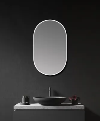 A modern bathroom vanity with a black sink and a white oval mirror above it.