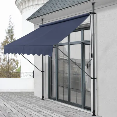 A dark blue awning is extended over a large window on a white building, with a wooden deck in the foreground.
