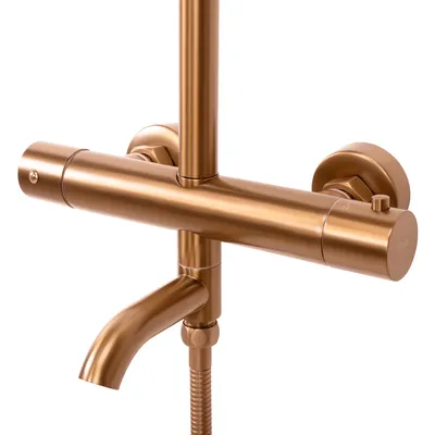 A close-up shot of a brushed copper shower faucet.