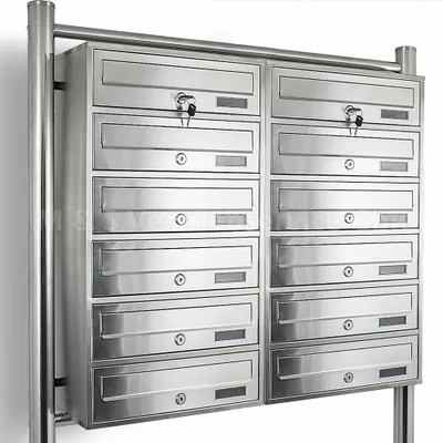 A stainless steel mailbox unit with 12 individual compartments, mounted on a metal frame.