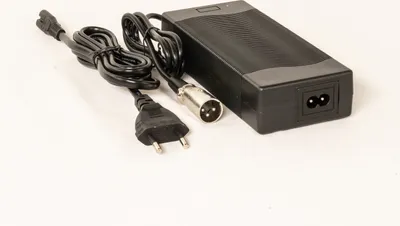 A black power adapter with cables and connectors on a white background.