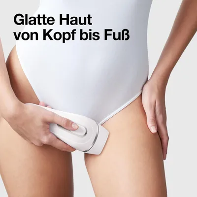 A person is using an IPL hair removal device on their thigh.