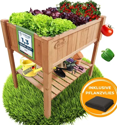 A raised garden bed filled with various types of lettuce and tomatoes, placed on a green grassy surface. Various gardening tools and accessories are also visible.